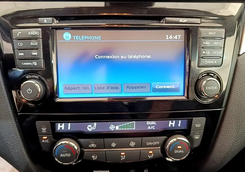 Gros plan sur l’écran tactile central et la console de climatisation du Nissan Qashqai blanc 2019.