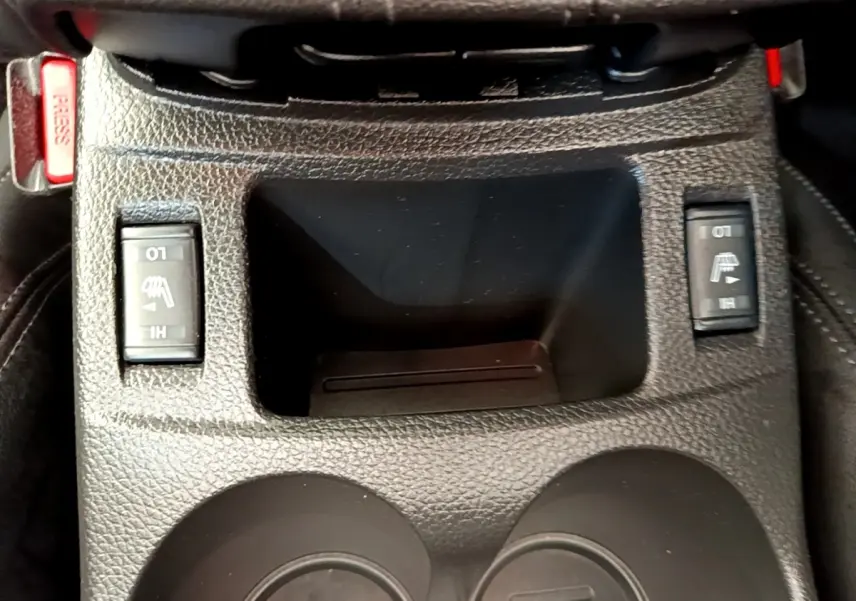 Gros plan sur la console centrale noire du Nissan Qashqai 1.3 DIG-T 140 Tekna avec commandes des sièges chauffants.