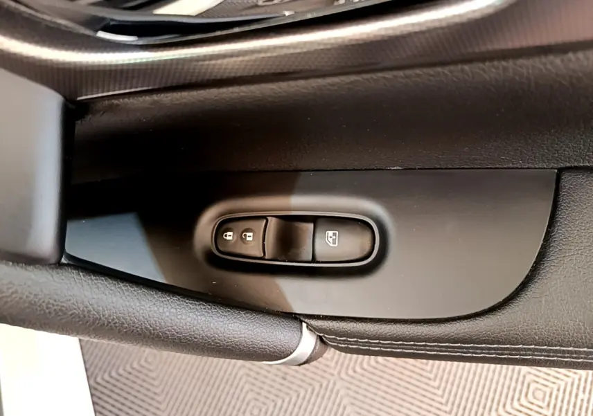 Détail des commandes de verrouillage et lève-vitres sur la porte intérieure côté conducteur du Nissan Qashqai blanc.