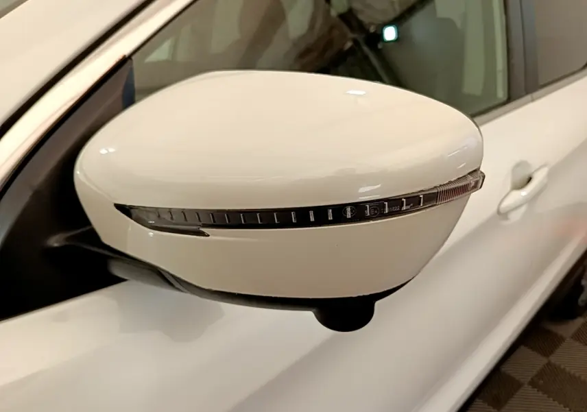 Rétroviseur droit blanc du Nissan Qashqai 2019 avec clignotant intégré, vue rapprochée en intérieur.