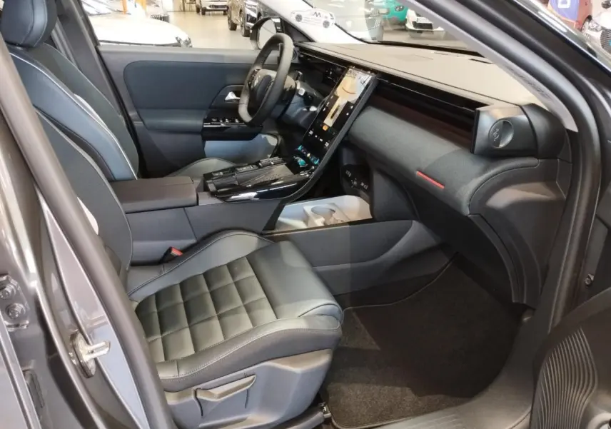 Vue intérieure côté passager avant du Citroën C5 Aircross gris platine, avec tableau de bord moderne et sièges cuir noir.