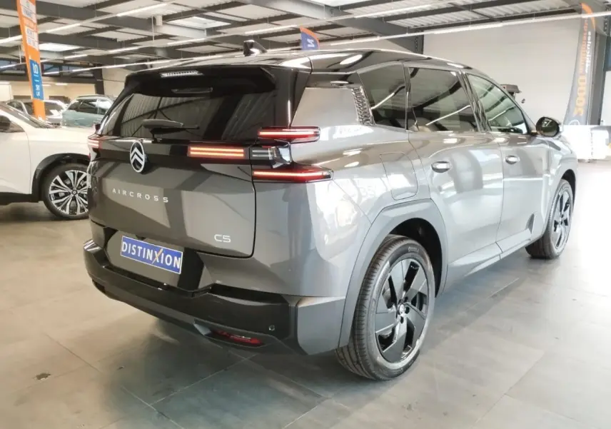 Vue 3/4 arrière droite d'un Citroën C5 Aircross gris platine avec toit noir et jantes alliage noires.