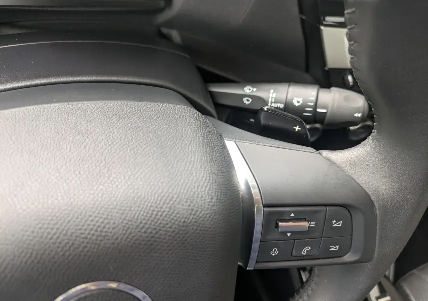 Gros plan sur le volant côté gauche de la Citroën C4 Hybrid 145 E-DCS6 Plus 2025, avec commandes intégrées.