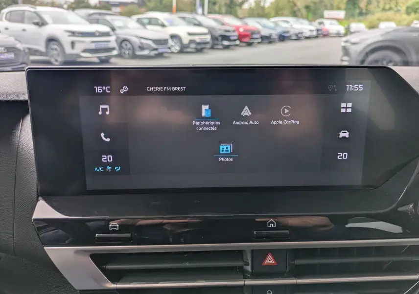 Vue rapprochée de l'écran tactile 10'' du tableau de bord du Citroën C4 Hybrid 145 E-DCS6 Plus, affichant la radio FM.
