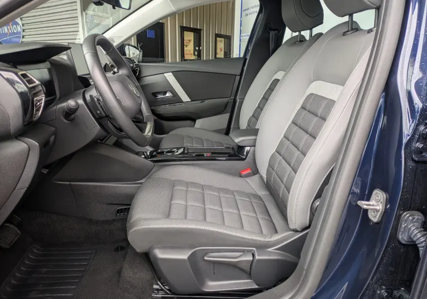 Gros plan sur les commandes de lève-vitres et réglages des rétroviseurs côté conducteur d'une Citroën C4 Hybrid 145 E-DCS6 Plus bleu foncé.