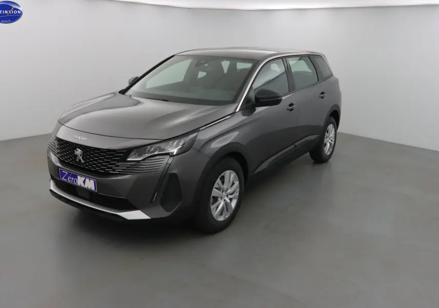 Peugeot 5008 gris platinium métal vue 3/4 avant droit dans un studio lumineux avec jantes argentées.