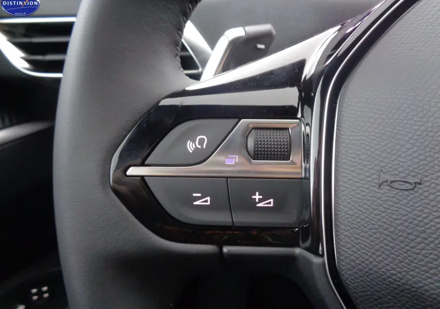 Gros plan sur les commandes du volant à gauche du Peugeot 5008 2023, finition Active Pack, intérieur noir.