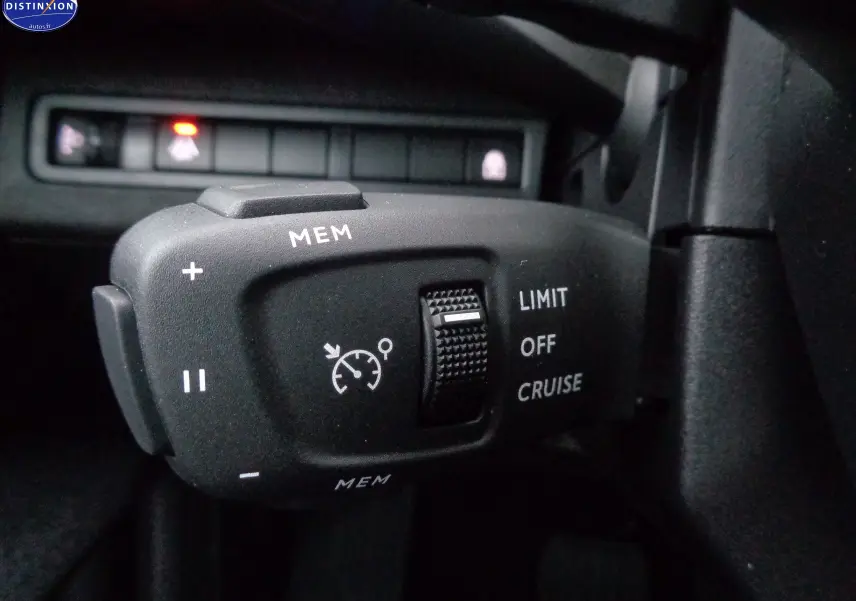 Gros plan sur la commande de régulateur de vitesse du Peugeot 5008 gris platinium, avec molette et boutons MEM, LIMIT, CRUISE.