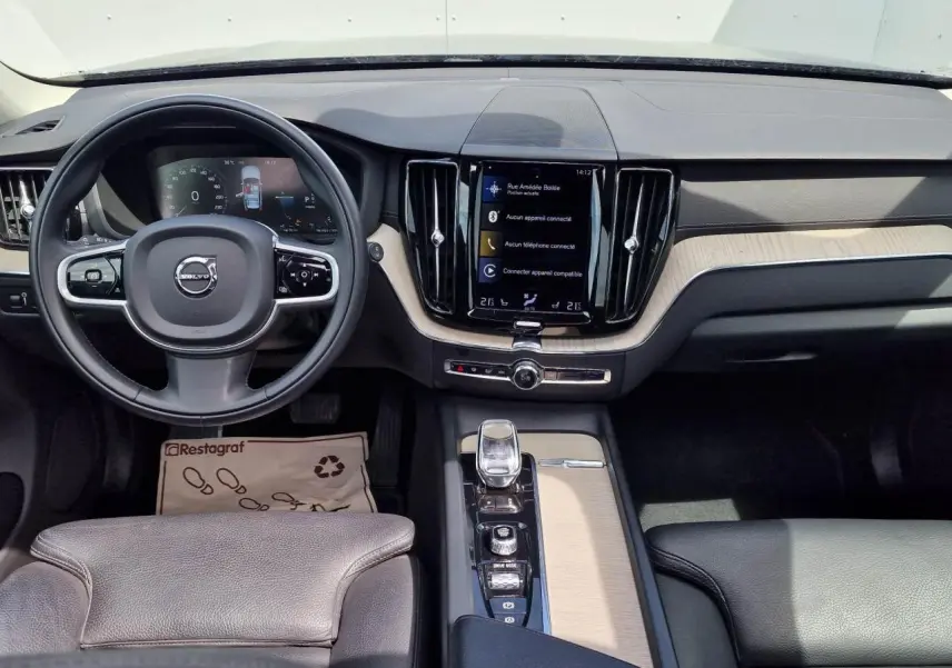 Vue intérieure du tableau de bord et console centrale du Volvo XC60 noir avec écran tactile vertical et volant multifonction.