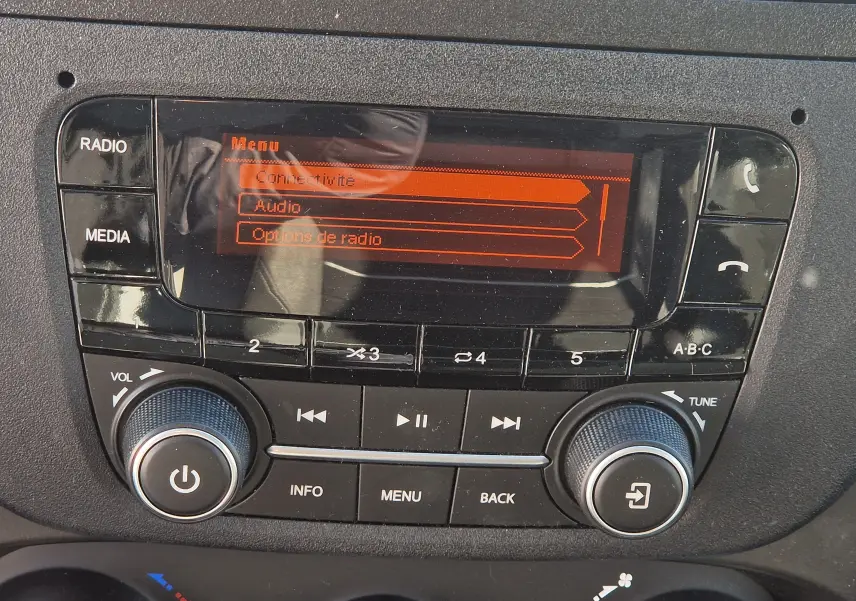 Gros plan sur la console centrale noire de l'IVECO Daily Fourgon 2022 avec écran radio affichant le menu connectivité.