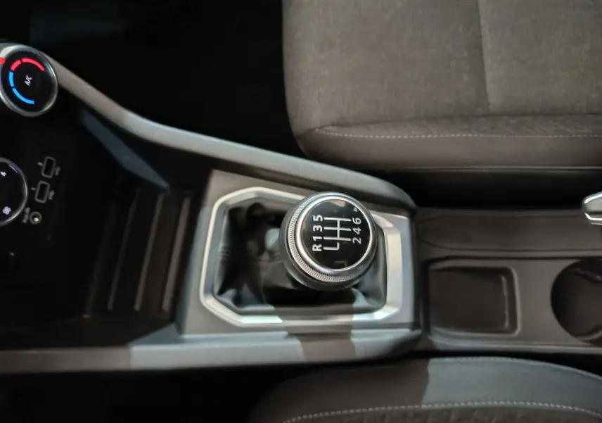 Gros plan sur le levier de vitesses manuel de la Renault Clio Business TCe 90 2021, avec sièges gris visibles.