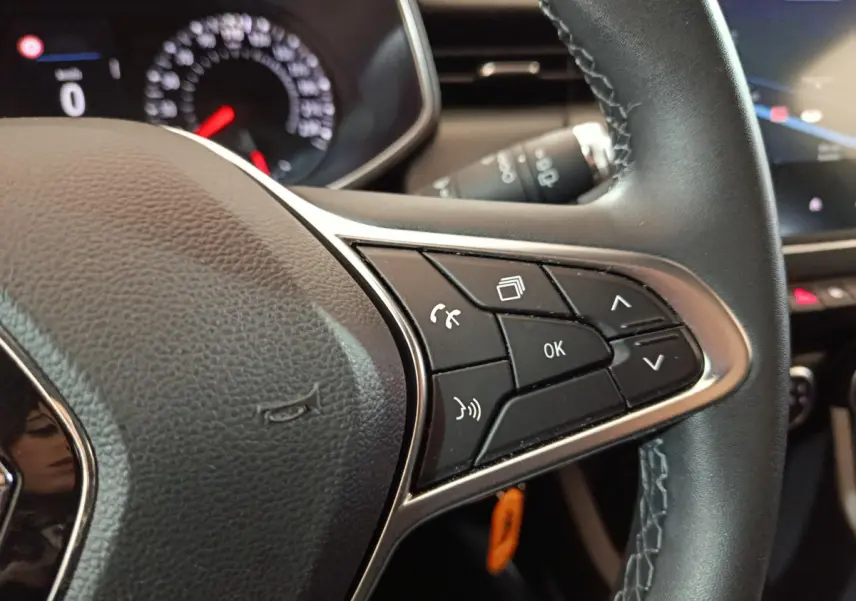 Gros plan sur le volant cuir noir de la Renault Clio Business TCe 90 avec commandes multifonctions à droite.