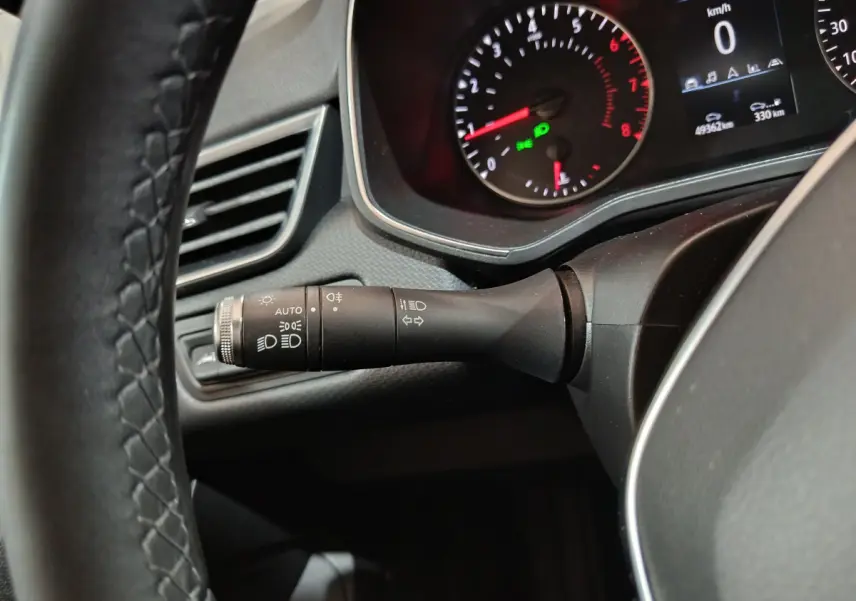 Gros plan sur la manette de phares et clignotants à gauche du volant cuir de la Renault Clio Business blanche 2021.