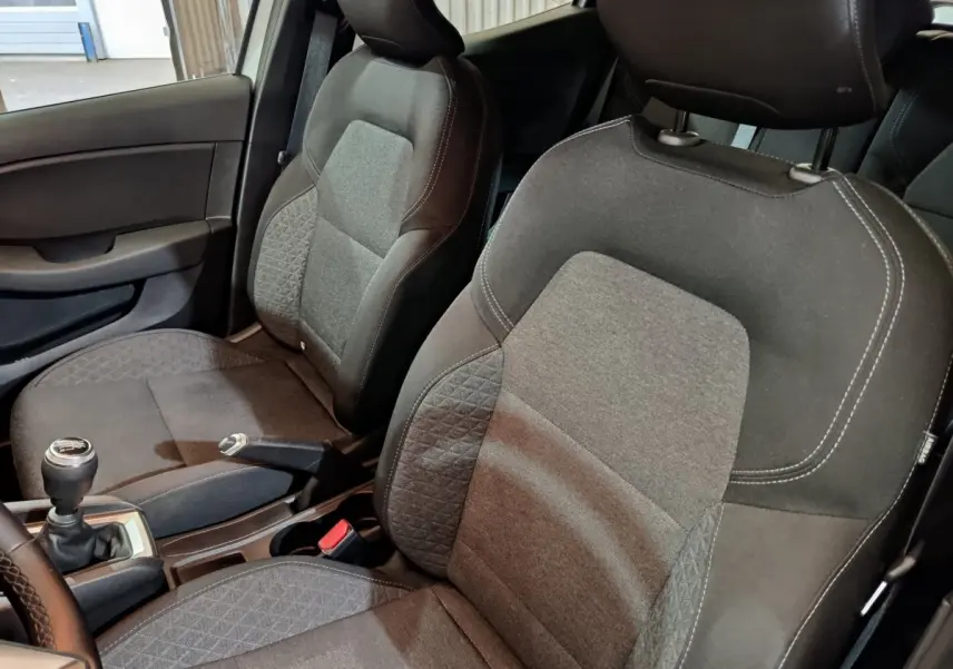 Vue intérieure rapprochée des sièges avant gris foncé et tissu texturé de la Renault Clio Business TCe 90 2021.