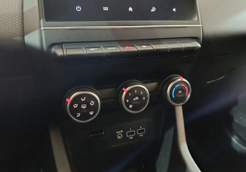 Gros plan sur les commandes de climatisation et connectiques USB du tableau de bord de la Renault Clio Business blanche 2021.