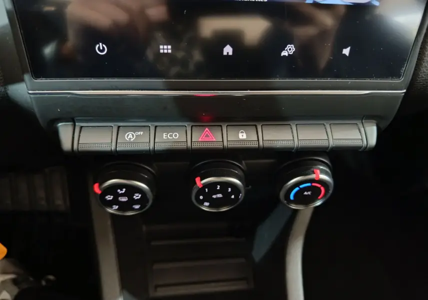 Gros plan sur la console centrale de la Renault Clio Business TCe 90 2021, montrant les commandes de climatisation et boutons fonctionnels.