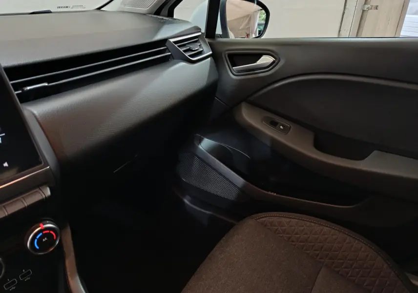 Intérieur côté passager de la Renault Clio Business TCe 90 blanc, tableau de bord et porte avec commandes visibles.