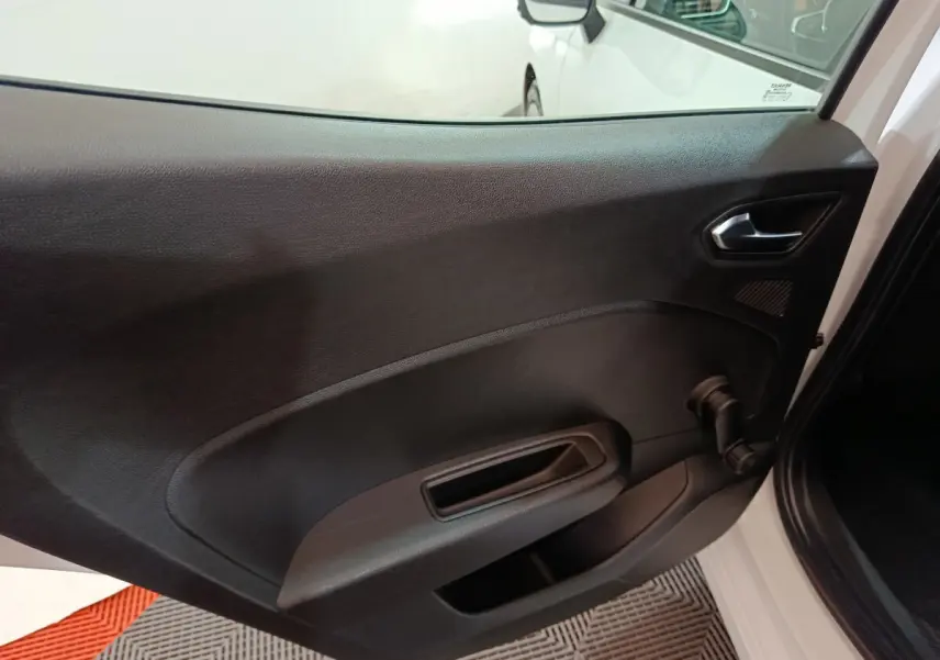 Vue du panneau de porte arrière droite noir mat d'une Renault Clio Business blanche, avec poignée et manivelle de vitre.