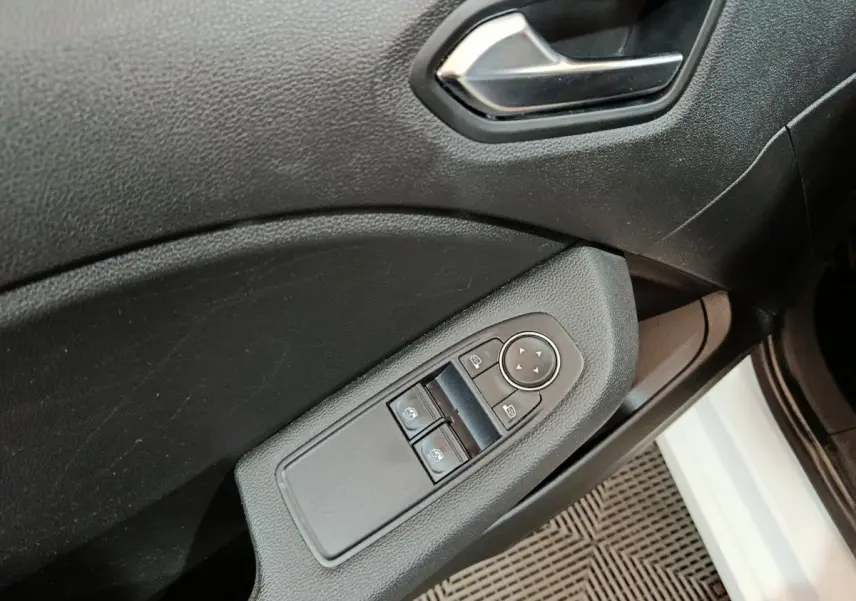 Détail des commandes de lève-vitres et rétroviseurs sur la porte côté conducteur d'une Renault Clio blanche 2021.