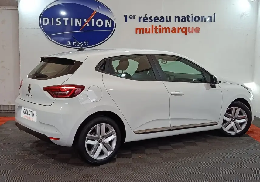 Renault Clio Business TCe 90 blanc vue de profil côté gauche en intérieur avec jantes alliage et feux arrière LED.