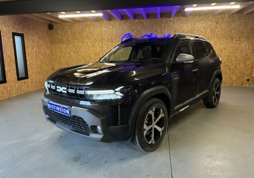 Dacia Duster 1.6 Hybrid noir en 3/4 avant droit, avec jantes noires et grises, dans un intérieur bois clair.