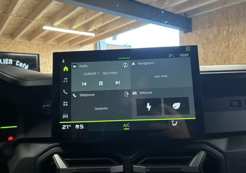 Écran tactile central du tableau de bord du Dacia Duster 1.6 Hybrid 140 Journey, affichant radio et navigation.