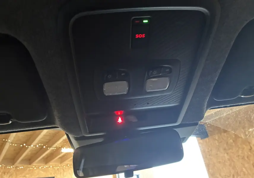 Vue intérieure du plafonnier du Dacia Duster noir 2025, avec boutons d’éclairage et témoin SOS allumé.