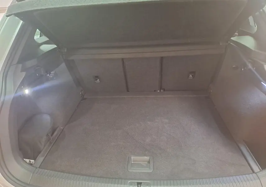 Coffre ouvert du Volkswagen Tiguan 2024 en Reflet d'Argent, vue intérieure arrière montrant l'espace de chargement vide.