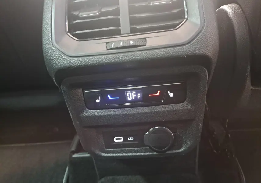 Détail du panneau de commandes arrière des sièges chauffants et prises USB du Volkswagen Tiguan 2024, intérieur noir.