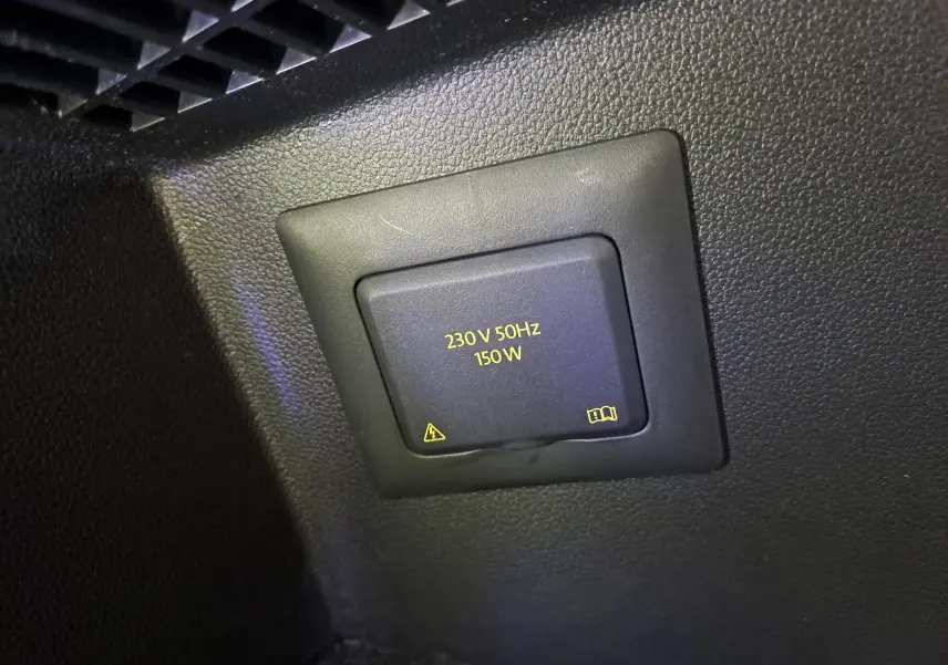 Gros plan sur la prise 230V 150W intégrée dans l'habitacle du Volkswagen Tiguan 2024 Reflet d'Argent.