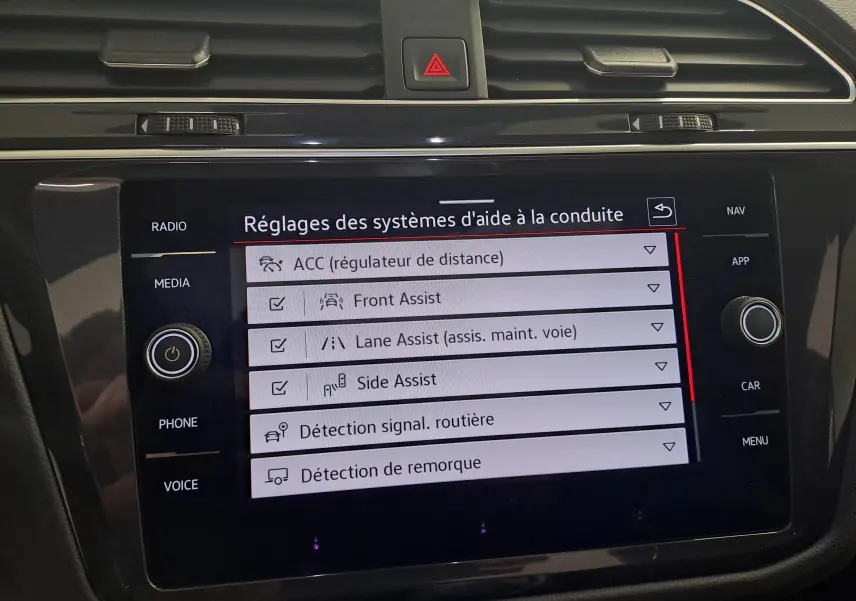 Écran tactile du tableau de bord du Volkswagen Tiguan 2024 affichant les réglages des aides à la conduite.