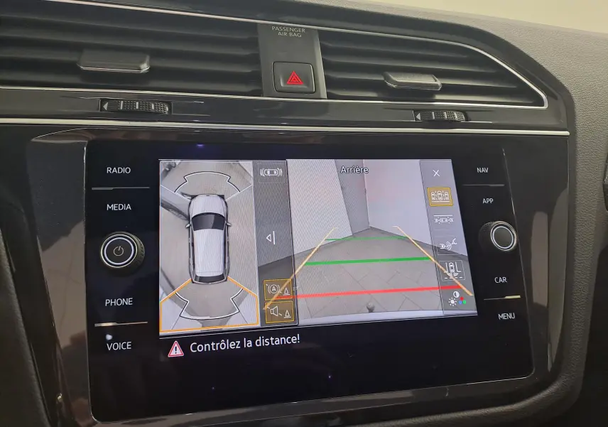 Vue rapprochée de l’écran multimédia du Volkswagen Tiguan 2024 affichant la caméra de recul et l’aide au stationnement.