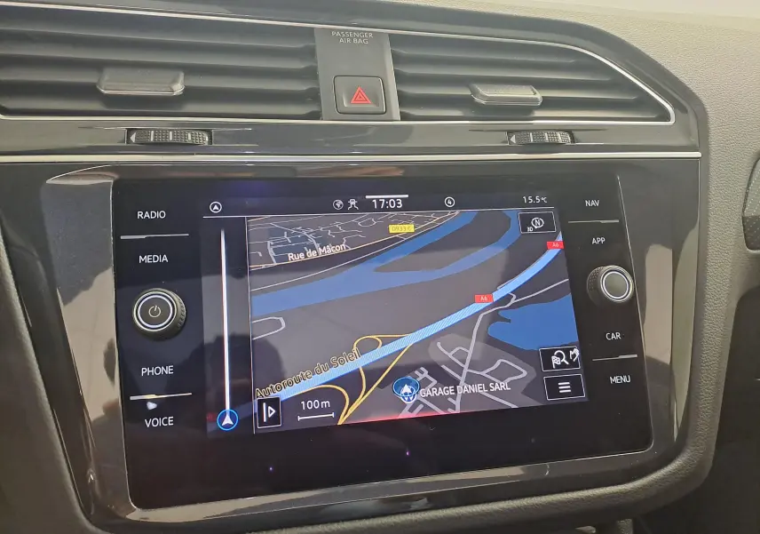 Écran tactile central du Volkswagen Tiguan 2024 affichant la navigation, entouré de commandes noires brillantes.