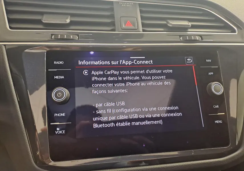 Écran tactile central du Volkswagen Tiguan 2024 affichant les options Apple CarPlay, entouré de commandes médias et navigation.