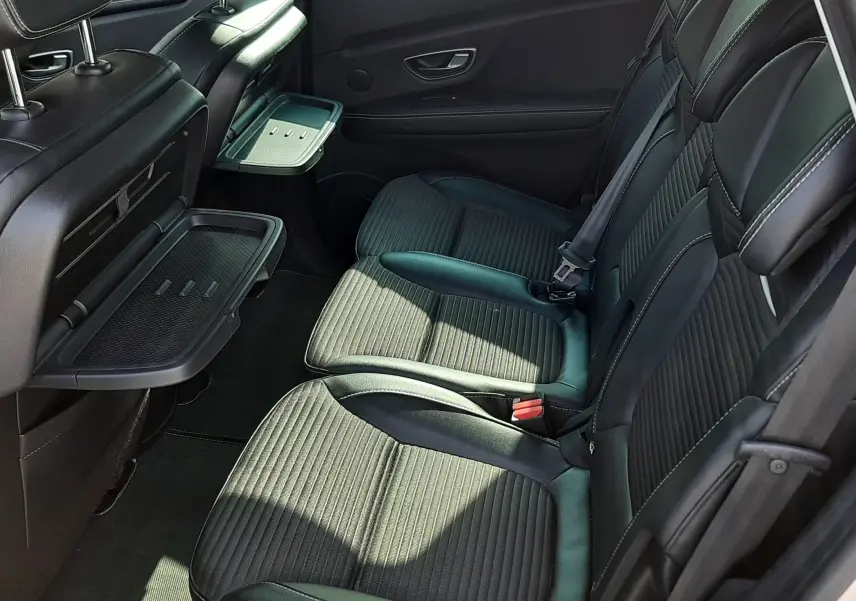 Vue intérieure côté droit des sièges arrière noirs avec tablettes rabattables sur un Renault Scénic IV 2018.
