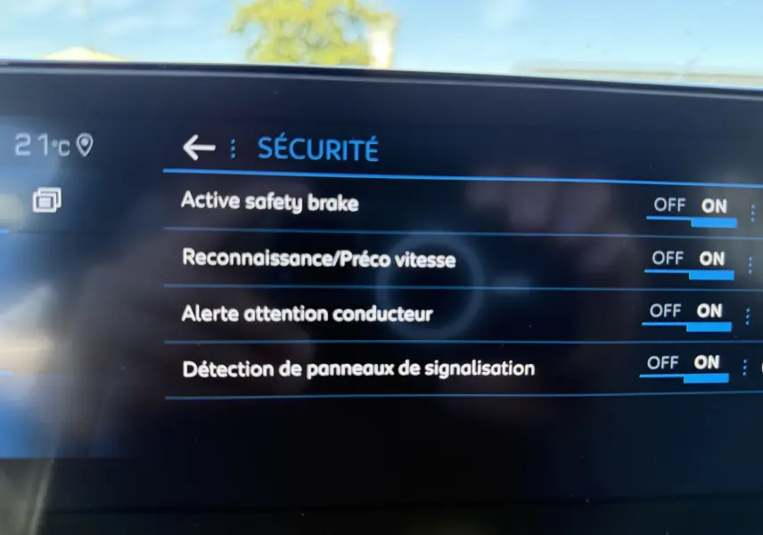 Écran intérieur du Peugeot 5008 2021 affichant les options de sécurité activées, avec fond noir et texte bleu et blanc.