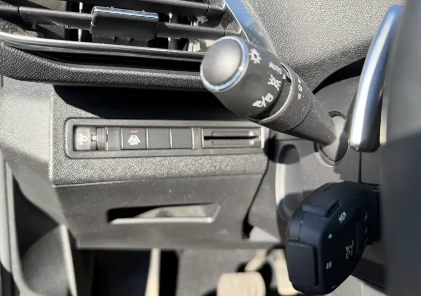 Détail intérieur du Peugeot 5008 1.5 HDi 130 Allure, montrant la commande des phares et la manette de clignotants côté gauche.