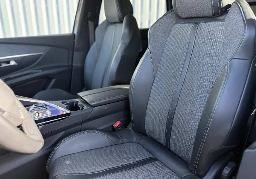 Gros plan sur les sièges avant en tissu gris et cuir noir du Peugeot 5008 1.5 HDi 130 Allure 2021, intérieur moderne.