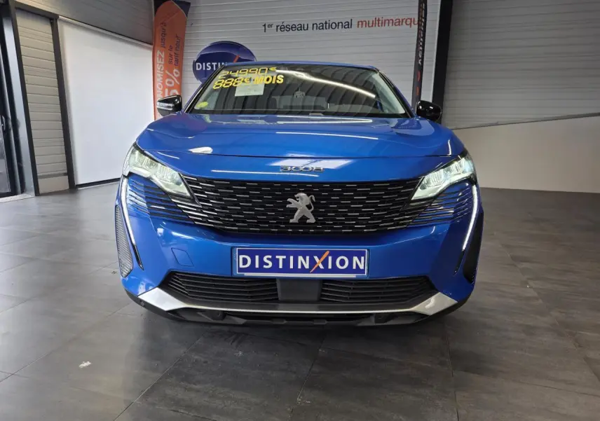 Vue avant d'un Peugeot 3008 bleu Iron avec calandre noire et logo lion chromé, en showroom intérieur.
