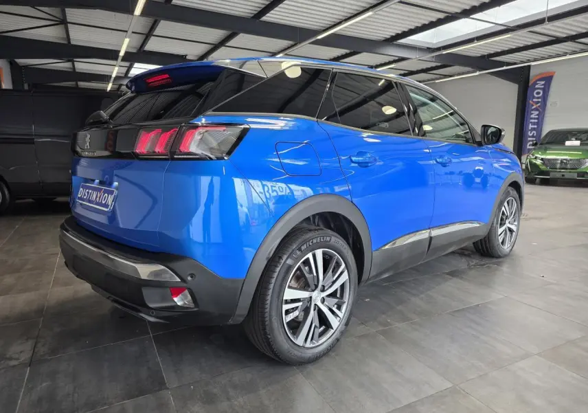 Peugeot 3008 bleu Iron vue 3/4 arrière droit en intérieur, avec jantes alliage bi-ton et vitres surteintées.