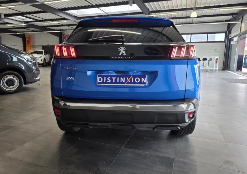 Vue arrière du Peugeot 3008 bleu Iron avec feux LED caractéristiques et bandeau noir brillant au-dessus du coffre.