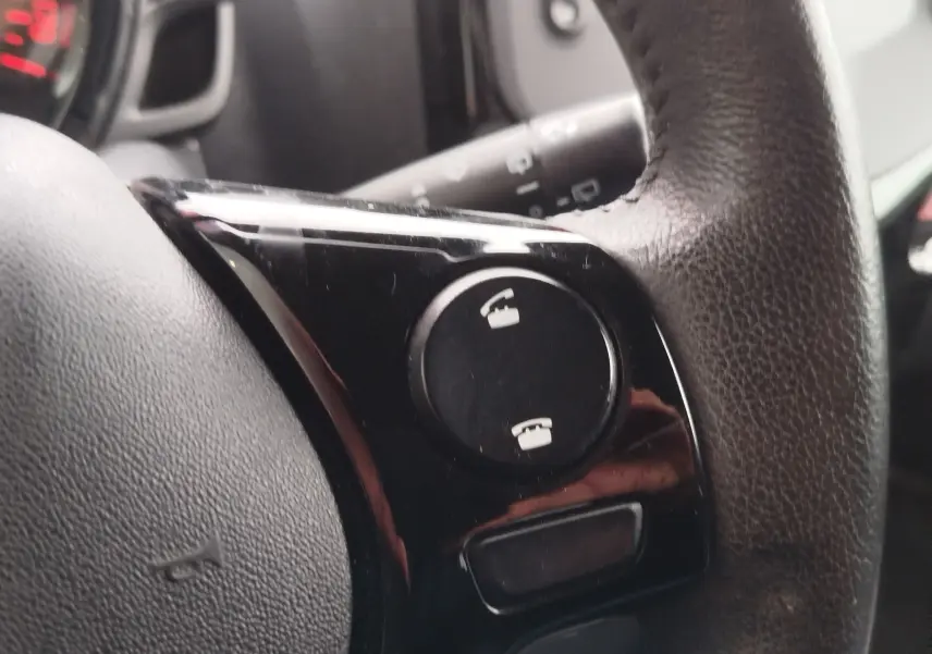 Gros plan sur les commandes téléphoniques sur le volant en cuir noir d’une Peugeot 108 2021.