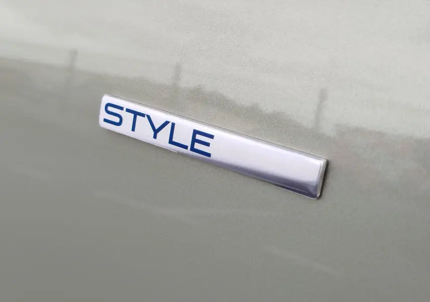 Gros plan sur l’inscription « STYLE » argentée et bleue sur la carrosserie Smooth Green d’une Peugeot 108.