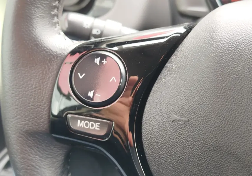 Gros plan sur les commandes audio noires intégrées au volant en cuir gris d'une Peugeot 108 2021.