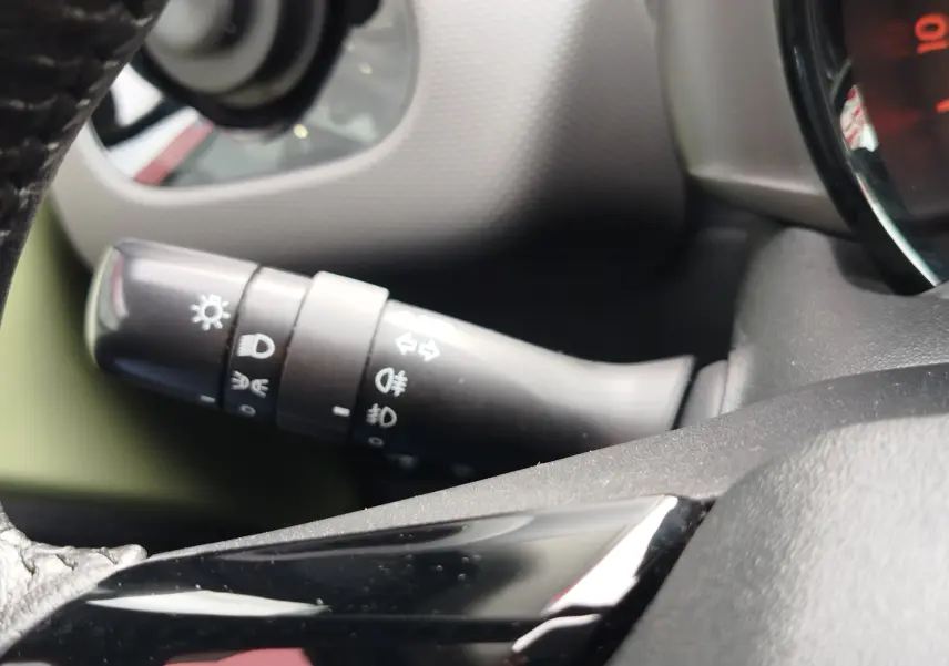 Gros plan sur la commande des feux et clignotants à gauche du volant dans l’habitacle d’une Peugeot 108 Smooth Green.