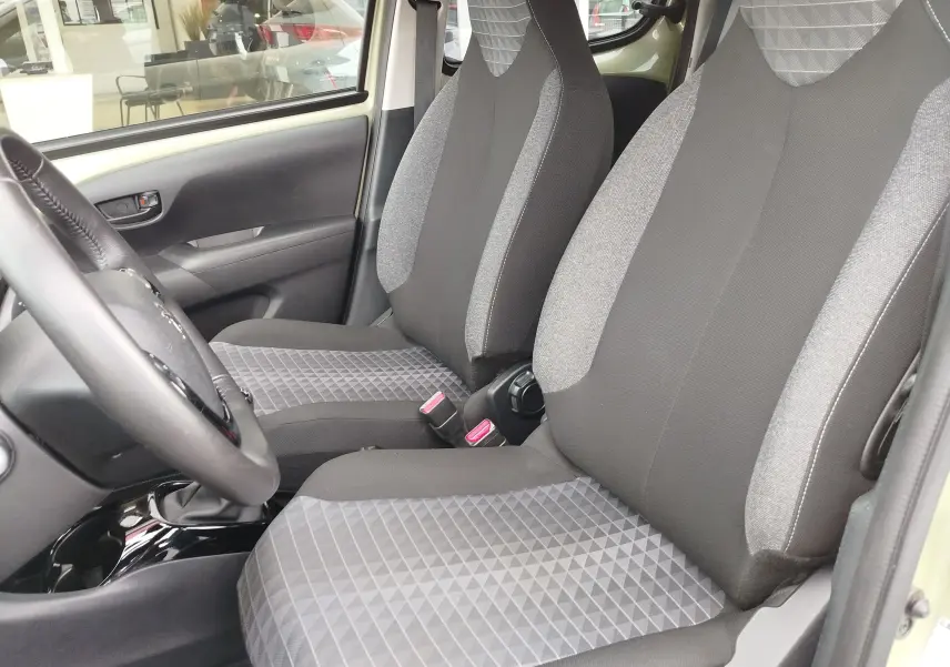 Vue intérieure côté gauche montrant les sièges avant gris à motifs géométriques du Peugeot 108 Smooth Green 2021.