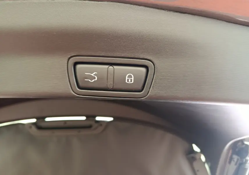 Gros plan sur les boutons d'ouverture et de verrouillage électrique du coffre du coffre gris foncé Alfa Romeo Stelvio 2024.