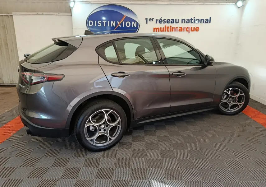 Profil droit d'un Alfa Romeo Stelvio gris foncé 2024 Sprint, avec jantes distinctives et feux arrière LED.