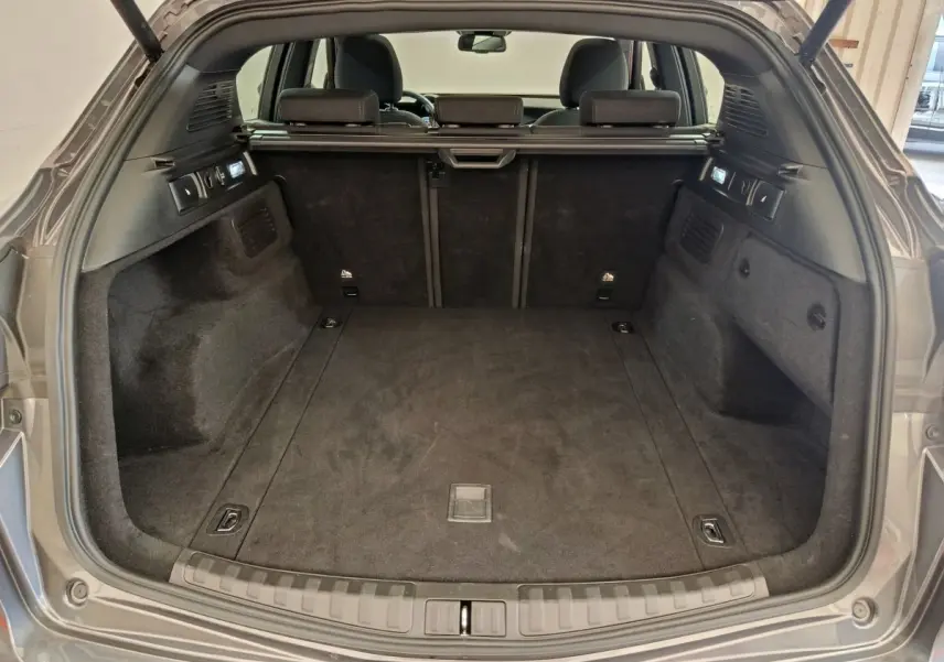 Coffre ouvert d'un Alfa Romeo Stelvio gris foncé 2024, vue arrière montrant l'espace de chargement et la banquette arrière.