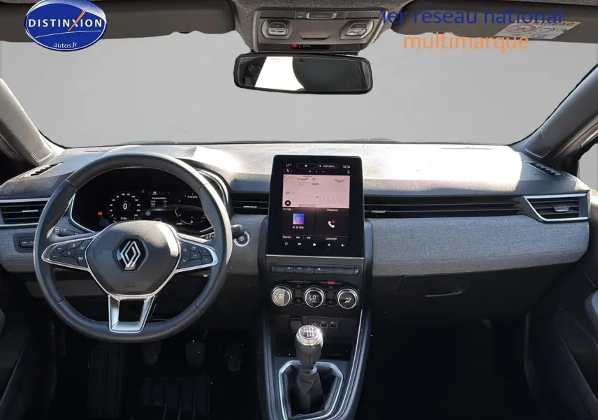 Tableau de bord et volant de la Renault Clio V gris pizzara avec écran tactile vertical et boîte manuelle visible.